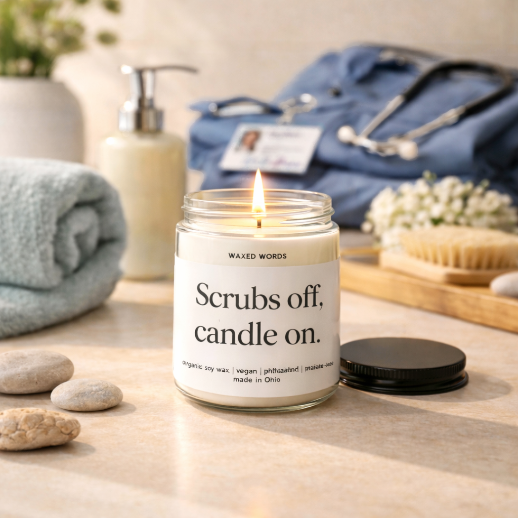 Waxed Words candle glowing on a bedside table with nurse badge, scrubs, and a dim lamp creating a relaxing nighttime atmosphere.
