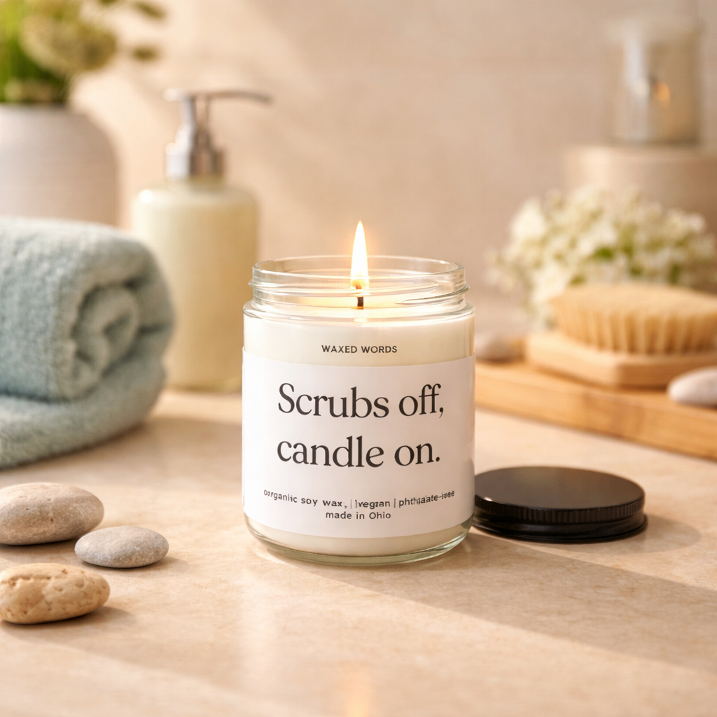 Waxed Words “Scrubs off, candle on” candle on a table with a mug, book, and nurse uniform nearby in a cozy home setting.