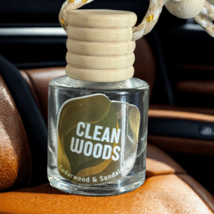 Close-up of glass car air freshener with wooden cap and braided rope on leather seat